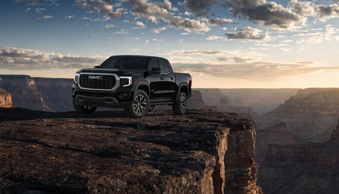 GMC Canyon truck with premium tonneau bed cover installed in rugged outdoor setting